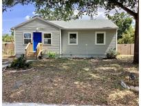 Charming home featuring a vibrant blue front door, complemented by a well-maintained yard at 1512 18Th W Ave, Bradenton, FL 34205