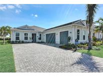 Charming single-story home featuring a three-car garage, manicured lawn, and a paved driveway at 17719 Palmiste Dr, Bradenton, FL 34202