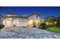 Elegant home showcasing a paved driveway, three-car garage, stone accents and a beautifully landscaped front yard at 17811 Roost Pl, Bradenton, FL 34211
