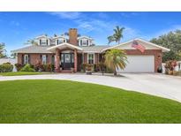 Charming brick home featuring a manicured lawn, American flag and attached two-car garage at 1904 Nw 79Th St, Bradenton, FL 34209