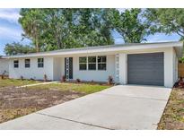 Charming single-story home featuring a gray garage door and fresh landscaping at 3193 Bellevue St, Sarasota, FL 34237
