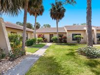 Inviting single story home with beautiful landscaping, walkway, and mature palm trees at 3627 Longmeadow # 39, Sarasota, FL 34235