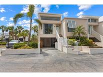 Modern condo featuring covered parking, a stairway to the front door, and lush tropical landscaping at 3803 E Bay Dr # 10, Bradenton Beach, FL 34217