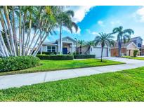 Charming single-story home with lush landscaping, palm trees, and a well-manicured lawn at 5320 Layton Dr, Venice, FL 34293