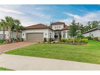 Charming single-story home featuring a tile roof, a brick driveway, and beautiful landscaping at 15605 Derna Ter, Bradenton, FL 34211
