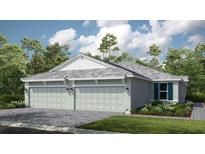 Charming single-story home boasts a two-car garage and well-manicured landscaping against a backdrop of lush trees and blue skies at 16234 Isola Pl, Bradenton, FL 34211