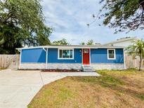 Charming blue home featuring a bright red door, stone accents, and a newly installed driveway at 5307 47Th Street E Ct, Bradenton, FL 34203