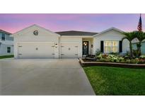 Charming single-Gathering home boasting a two-car garage, well-manicured lawn, and colorful flower beds at 5904 114Th E Dr, Parrish, FL 34219