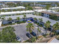 An aerial view of a condo building featuring multiple units and ample parking surrounded by tropical landscaping at 6713 Midnight Pass Rd # 4, Sarasota, FL 34242