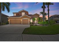 Two-story home with a well-manicured lawn, mature palm trees, and a two-car garage, perfect for Florida living at 7626 Double Pine Dr, Sarasota, FL 34240