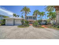 Charming two-story home with lush landscaping, a three-car garage, and a welcoming brick path at 878 Freeling Dr, Sarasota, FL 34242
