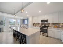 Bright kitchen features quartz countertops, stainless steel appliances, and eat-in breakfast nook with water view at 910 Tidewater Shores Loop # 103, Bradenton, FL 34208