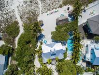 Breathtaking aerial view of a beachfront property with a pool, lush landscaping, and beach access at 102 & 104 48Th St, Holmes Beach, FL 34217