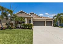 Beautiful home featuring a three-car garage, manicured landscaping, and a welcoming front porch at 11513 11Th E Ave, Bradenton, FL 34212