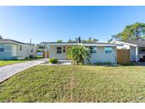 Charming single-story home featuring a well-maintained lawn and a light gray exterior at 1234 29Th St N, St Petersburg, FL 33713