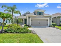 Beautiful home featuring manicured landscaping, a two-car garage, and charming architectural details at 1739 Lake Verona Cir, Bradenton, FL 34211