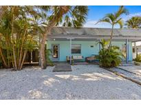 Charming, light-blue single-story home featuring a landscaped yard with white pebbles and an inviting front porch at 205 71St St # B, Holmes Beach, FL 34217