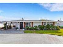 Charming single-story home featuring a well-manicured lawn and a covered carport, offering both curb appeal and convenience at 3219 Florida Blvd, Bradenton, FL 34207
