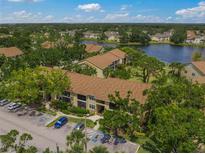 An aerial view of the condo community with waterfront views, ample parking and mature trees at 4037 Crockers Lake Blvd # 17, Sarasota, FL 34238