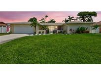 Charming single-story home featuring a well-manicured lawn, complemented by lush landscaping and a two car garage at 5126 15Th W Ave, Bradenton, FL 34209