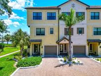 Inviting townhouse exterior featuring a brick driveway, lush landscaping, and attractive architectural details at 5561 Cannes Cir # 5101, Sarasota, FL 34231