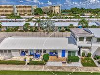 Charming villa featuring a covered patio with blue furniture and a well-maintained landscape at 5858 Midnight Pass Rd # 27, Sarasota, FL 34242