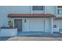 Charming townhouse featuring an attached one car garage and a welcoming front entrance with colorful landscaping at 6836 Midnight Pass Rd # 6836, Sarasota, FL 34242