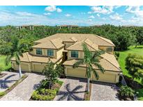 Elegant home with a red tiled roof, lush landscaping and three-car garage at 6907 Grand Estuary Trl # 104, Bradenton, FL 34212
