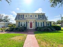 Charming two-story home with a well-maintained lawn and landscaped front yard and a brick walkway leading up to the front door at 708 32Nd W St, Bradenton, FL 34205