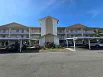 Condo exterior with a white facade, balconies, covered parking, and a well-maintained landscape at 7201 29Th Avenue W Dr # 306, Bradenton, FL 34209
