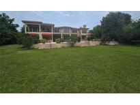 Expansive backyard of this two-story home features a generous lawn with multiple patios and lovely landscaping at 7732 N Mobley Rd, Odessa, FL 33556