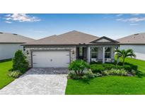 Beautiful single-story home with manicured lawn, stone accents and a two-car garage at 10724 Spring Tide Way, Parrish, FL 34219
