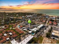 Breathtaking aerial view of the property with beautiful water views and a colorful sunset backdrop at 116 Vista Hermosa Cir # 204C, Sarasota, FL 34242
