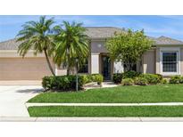 Charming single-story home with mature landscaping, palm trees, and a well-maintained lawn at 12007 Clubhouse Dr, Lakewood Ranch, FL 34202