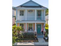Charming two-story home with a welcoming front porch, coastal decor, and lush landscaping at 12520 Shimmering Oak Cir, Venice, FL 34293