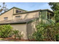 Two-story home featuring a lattice balcony, neutral-toned exterior, and lush greenery for added privacy at 1609 Bayhouse Point Dr # 232, Sarasota, FL 34231