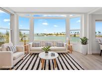 Bright living room boasts a large bay window with scenic waterfront views and stylish decor at 174 Golden Gate Pt # 21, Sarasota, FL 34236