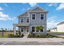 Charming two-story home with blue siding, a covered porch, and well-manicured landscaping at 204 Eagleston Ln, Lakewood Ranch, FL 34240