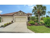Charming home featuring a well-maintained front yard with lush landscaping, three car garage and a tile roof at 229 Alento Ct, Nokomis, FL 34275