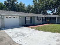 Charming single-story home with a well-maintained lawn, attached garage, and a brick walkway leading to the front door at 236 Davis Blvd, Sarasota, FL 34237