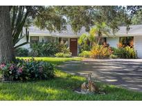 Charming home featuring lush landscaping and a circular driveway, creating curb appeal at 3010 E Forest Lake Dr, Sarasota, FL 34232
