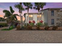 Inviting condo exterior with lush landscaping and ample parking in a tropical setting at sunset at 6204 Midnight Pass Rd # 201, Sarasota, FL 34242