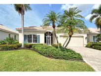 Charming single-story home with a well-manicured lawn, mature palm trees, and a tile roof at 7124 Rue De Palisades # 21, Sarasota, FL 34238