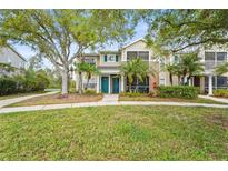 Charming townhouse with well-manicured lawn, mature trees, and inviting, covered front porches at 8821 Manor Loop # 205, Lakewood Ranch, FL 34202