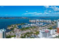 Breathtaking aerial view of waterfront condo building, with expansive marina and blue ocean background at 101 S Gulfstream Ave # 16C, Sarasota, FL 34236
