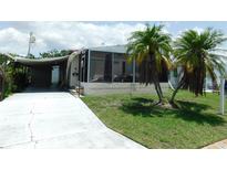 Charming home with a covered carport and a screened-in porch, complemented by palm trees at 1212 45Th E Ave, Ellenton, FL 34222