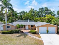 Charming ranch-style home featuring a two-car garage, lush landscaping, and inviting front porch at 2726 Silver King Way, Sarasota, FL 34231