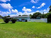 Charming single-story home with a well-maintained lawn, mature trees, and a white picket fence at 3600 Wisteria Pl, Punta Gorda, FL 33950