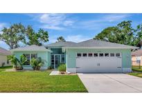 Charming single-story home with a well-manicured lawn, blue exterior paint and a two-car garage at 3718 61St E Dr, Bradenton, FL 34203