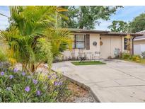 Charming single-story home featuring lush landscaping and a cozy outdoor seating area, perfect for enjoying the Florida sunshine at 4023 Chestnut Ave, Sarasota, FL 34234